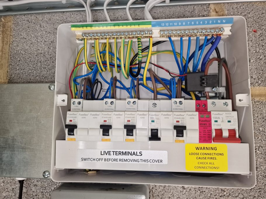 New fire‑rated RCBO consumer unit with SPD, tidy wiring, and cables secured in metal containment.