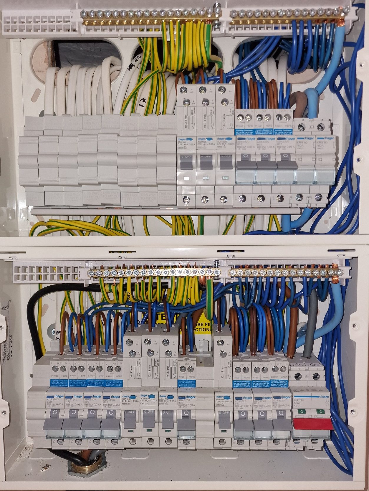 Double DIN‑rail single‑phase consumer unit with RCBOs and SPD, neatly dressed and professionally installed with cover removed to show cable 